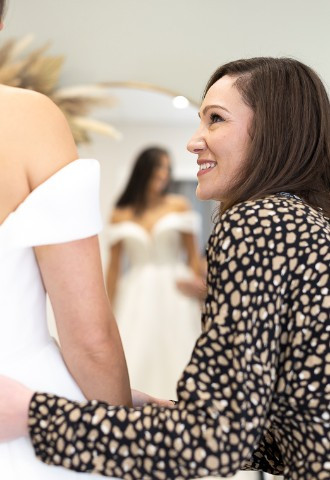 Lady helping bride at Your Story bridal boutique