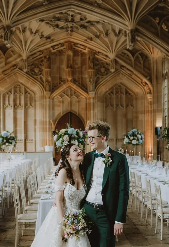 Bride and groom standing in front of their wedding reception tables