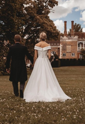 Bride and groom pose for photos in the grounds of Nether Winchendon House