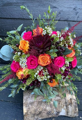a vibrant bouquet of burgundy, bright pink and orange flowers including roses and dahlias made by ann laing flowers in harwell oxfordshire