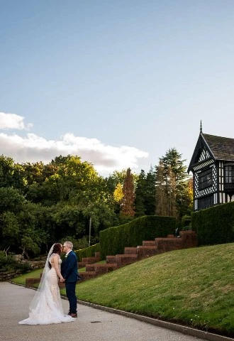 Bride and Groom kiss outside of Bramall Hall