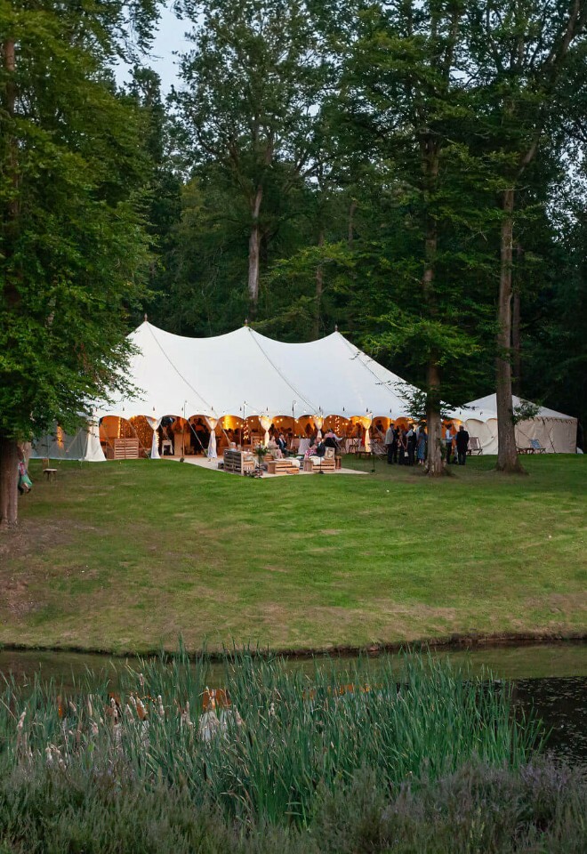 Magical luxury marquee hidden among woodland with a golden glow coming from inside