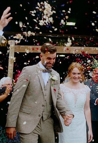 Bride and groom being showered in confetti