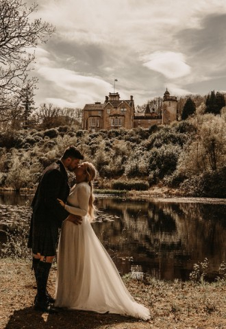 Bride & groom kissing at Auchen Castle - romantic castle wedding venue in Scotland