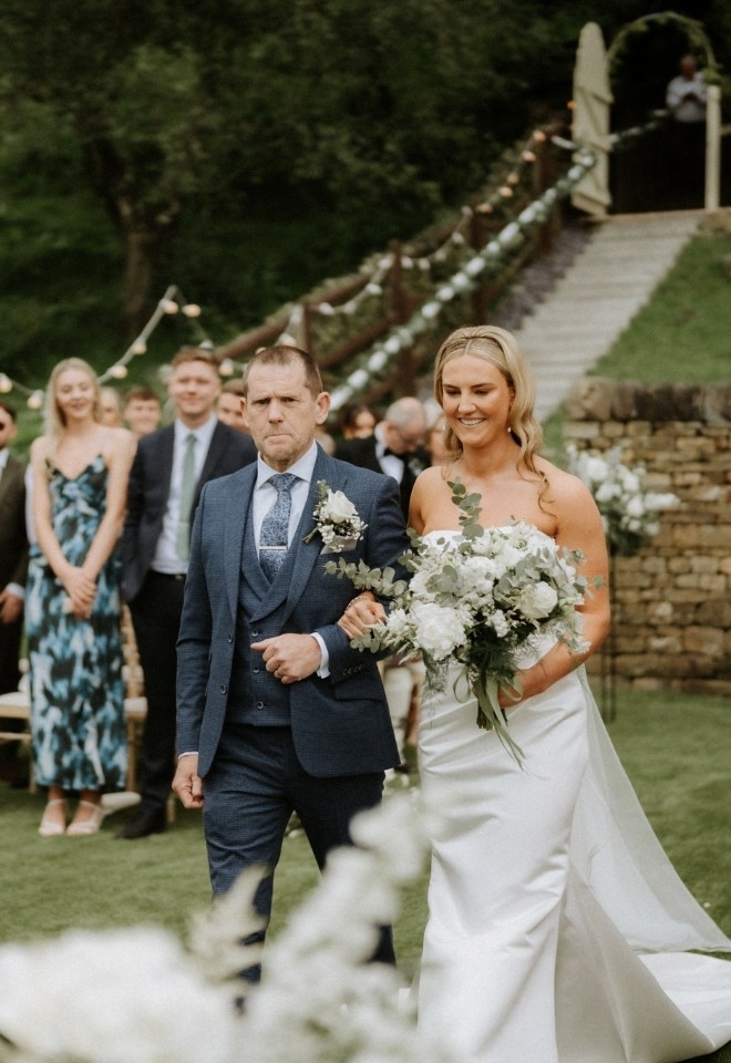 father of the bride walking his daughter to the alter to get married at The Stables Wedding Farm