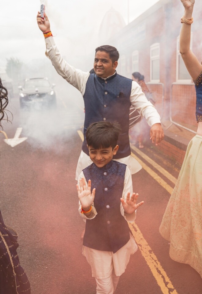 Joyful wedding celebration with guests dancing outdoors during a multicultural wedding event