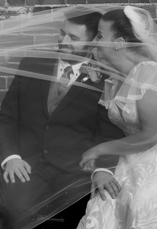 Bride and groom under veil