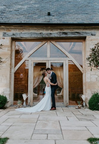 Bride and groom outside the Threshing Barn at Upcote