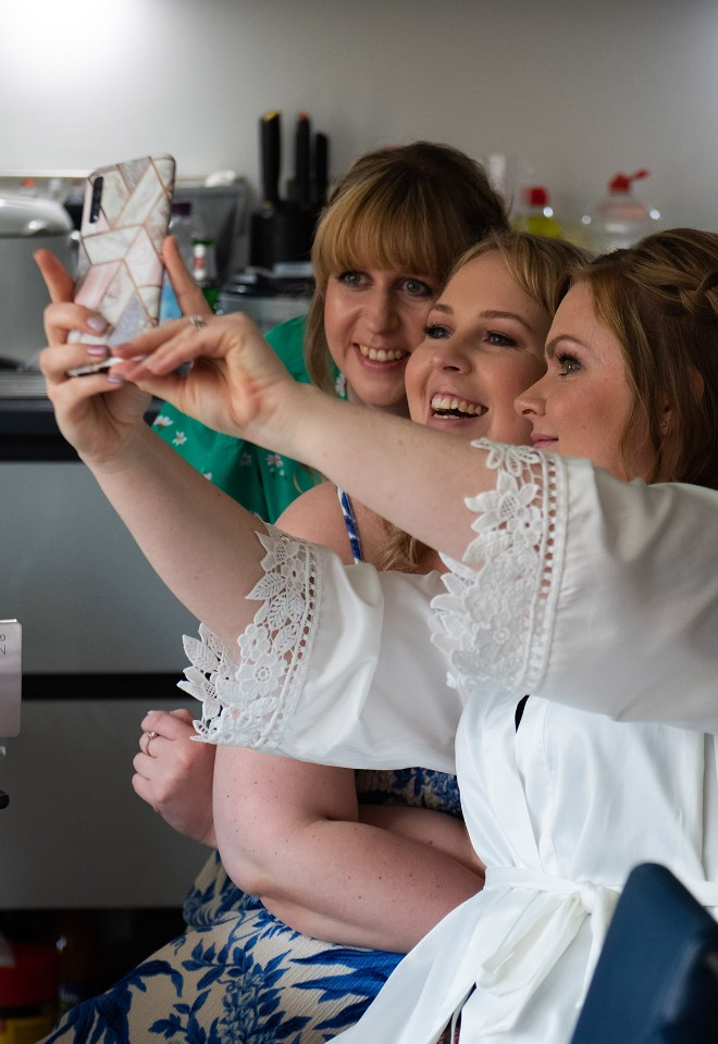 Bridesmaids snatch a group selfie during the wedding preparations, hair and make up completed