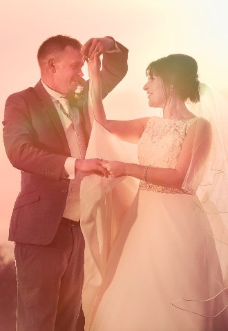 Bride and groom dancing together in a field at sunset wedding photographer Paul Griffiths Oxfordshire wedding