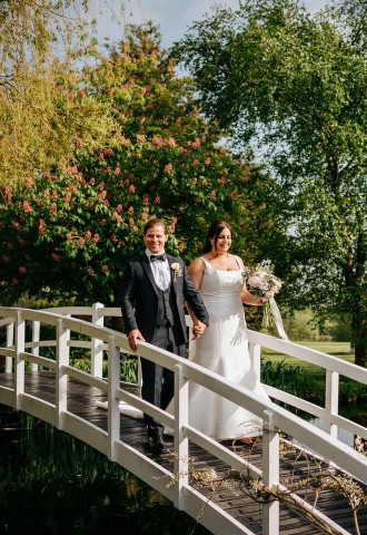 Wedding couple crossing the bridge at High House