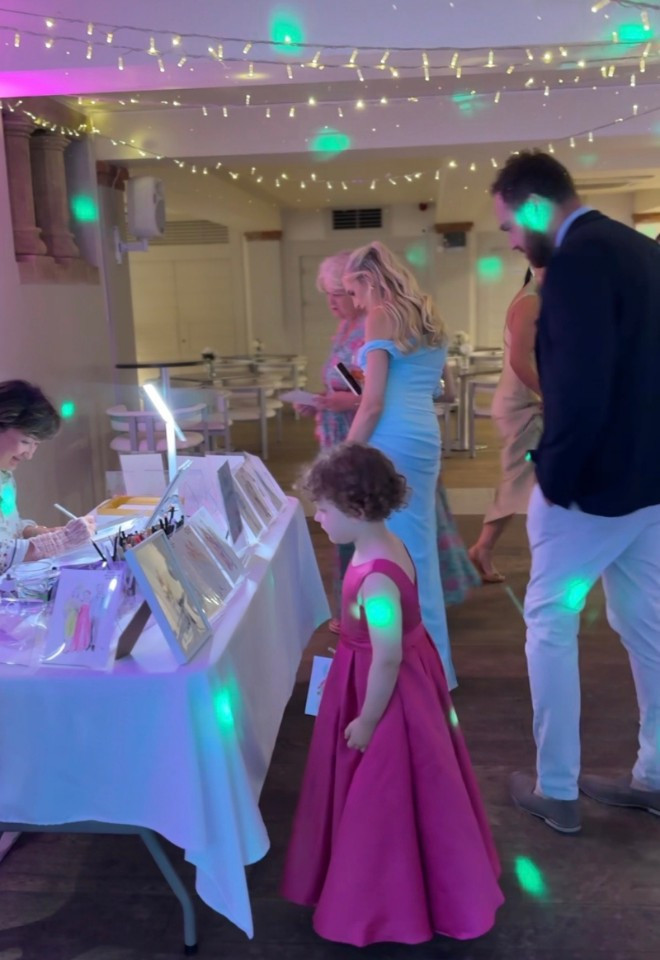 GUESTS ENJOYING THE ILLUSTRATION DISPLAY ON THE WEDDING DAY