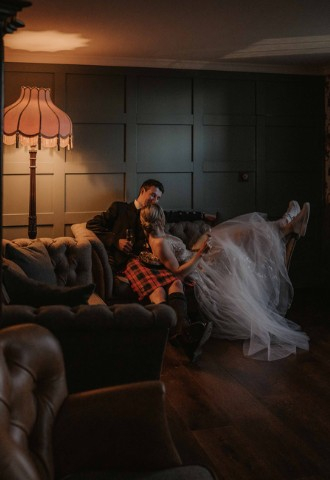 Bride & groom lounging in the Ante Room at Auchen Castle - a romantic castle wedding venue in Scotland