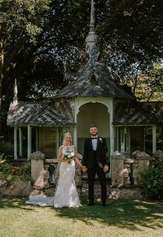 Bride and groom pose at Chateau Rhianfa, Anglesey