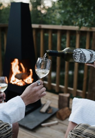 pouring wine by the fire pit, luxury tree yurt, eavestone lake