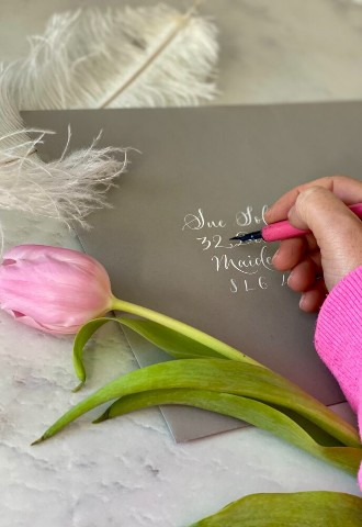 Hand written calligraphy wedding stationery with tulips and feathers