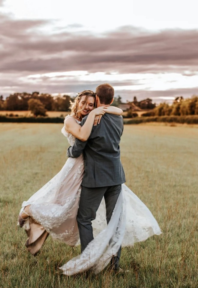 Bride and Groom in field of Oxfordshire wedding barn 