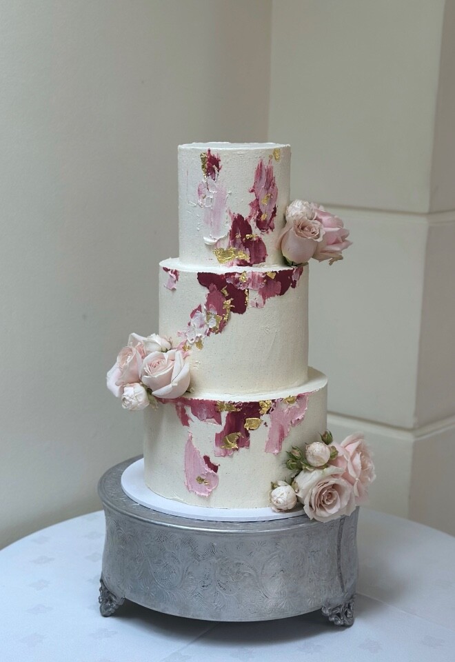 Buttercream wedding cake daubed with blush pink, burgundy & gold leaf, London