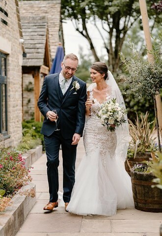 Wedding couple walk through wedding venue Wild Thyme and Honey Cotswolds