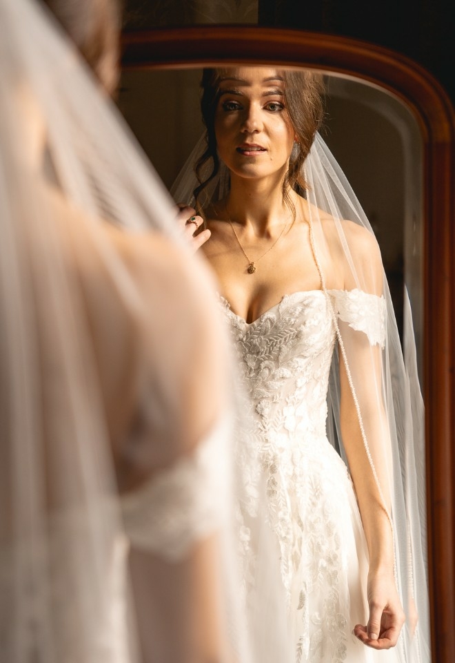 Bride admiring her beauty in the full length mirror