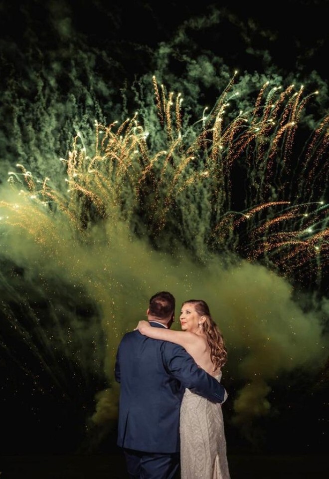 Romantic wedding fireworks display at Burnham Beeches, with bride and groom embracing beneath a dramatic golden night-time fireworks finale, created by Powerhouse Pyrotechnics 