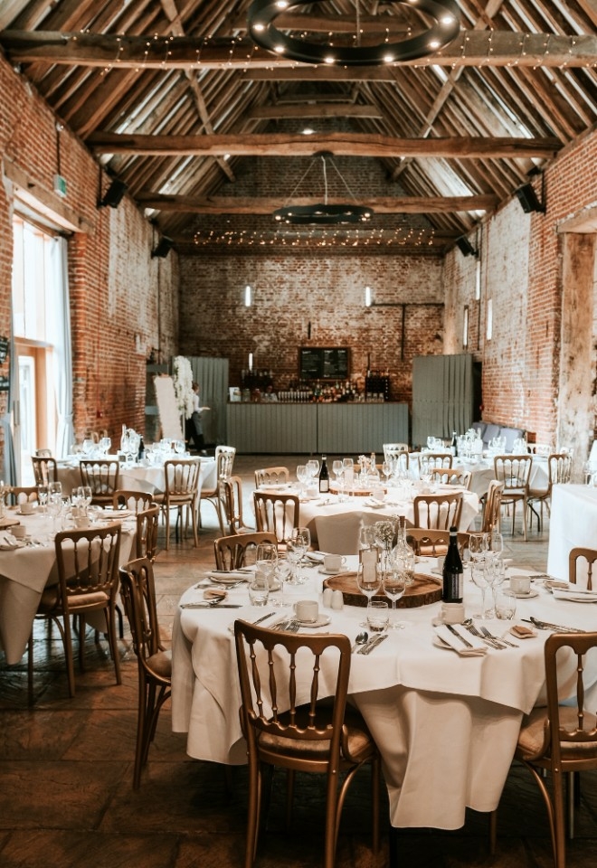 Copdock Hall interior barn with circular tables and gold chairs