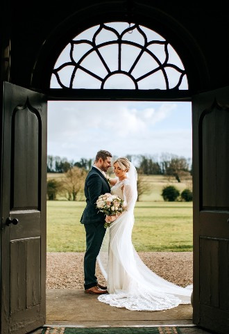 Bride and groom pose at Howsham Hall, North Yorkshire