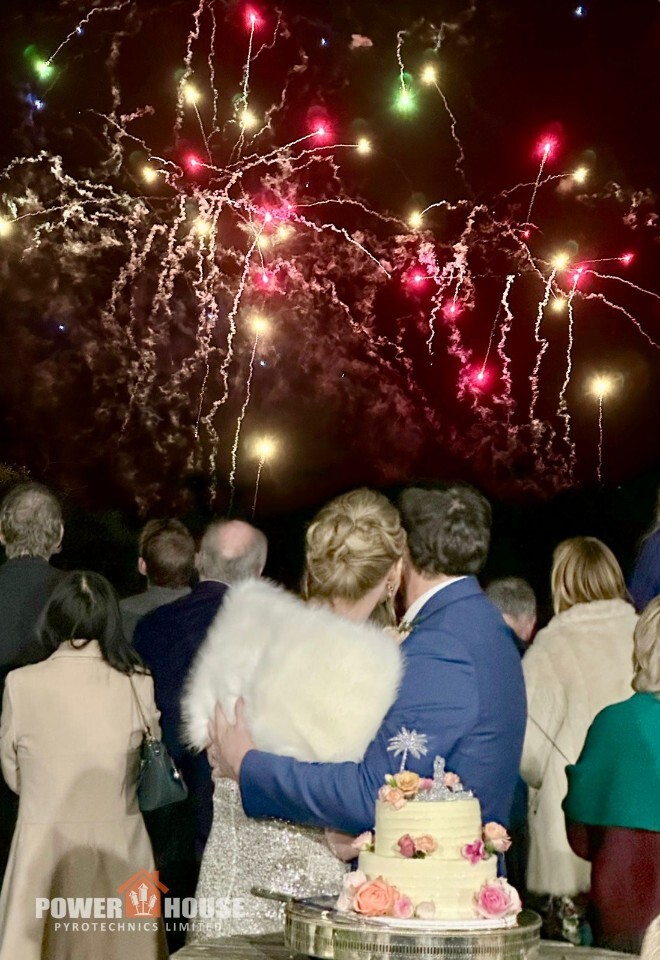 Wedding fireworks display at Horsley Towers, with bride and groom embracing while watching a spectacular night-time fireworks show.