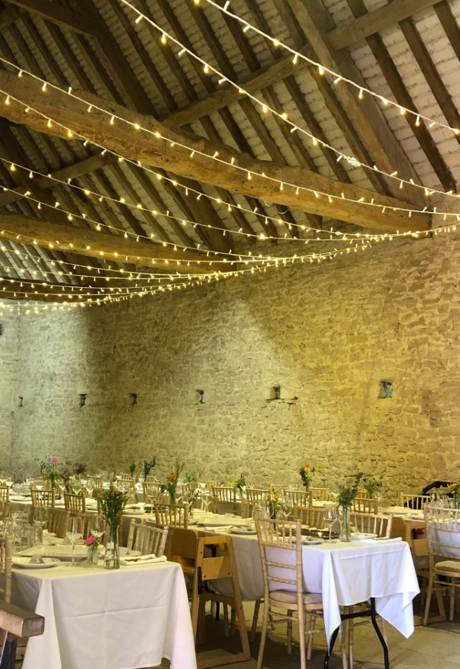 Banqueting tables with chivari chairs and string lights