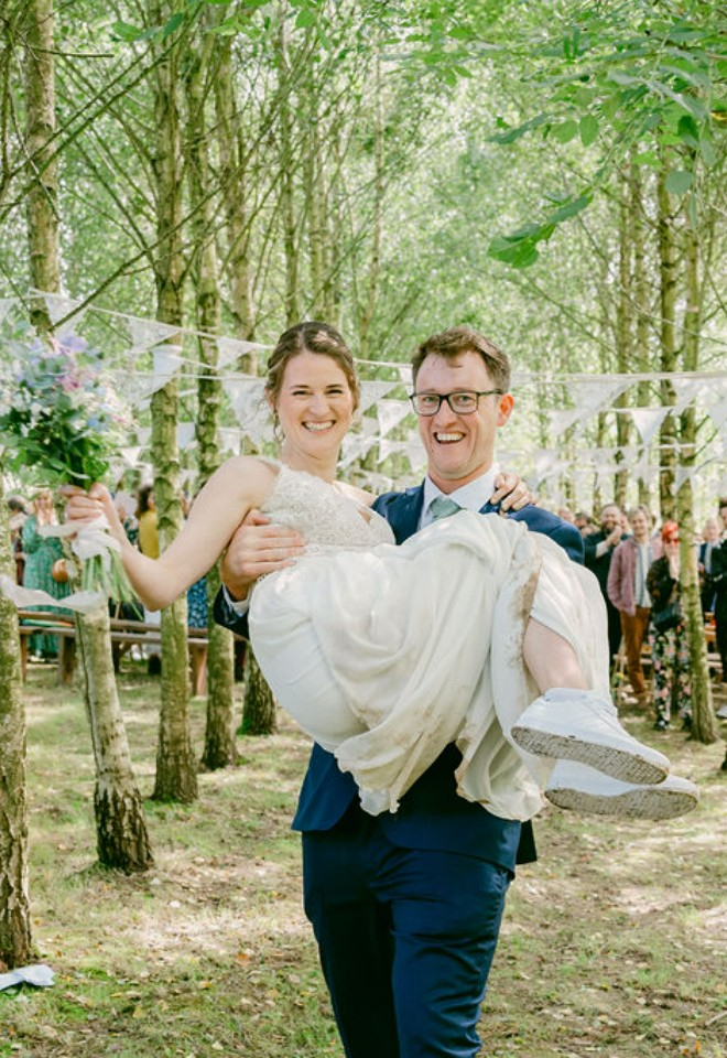 Groom carrying bride down the aisle at Higher Holcombe 