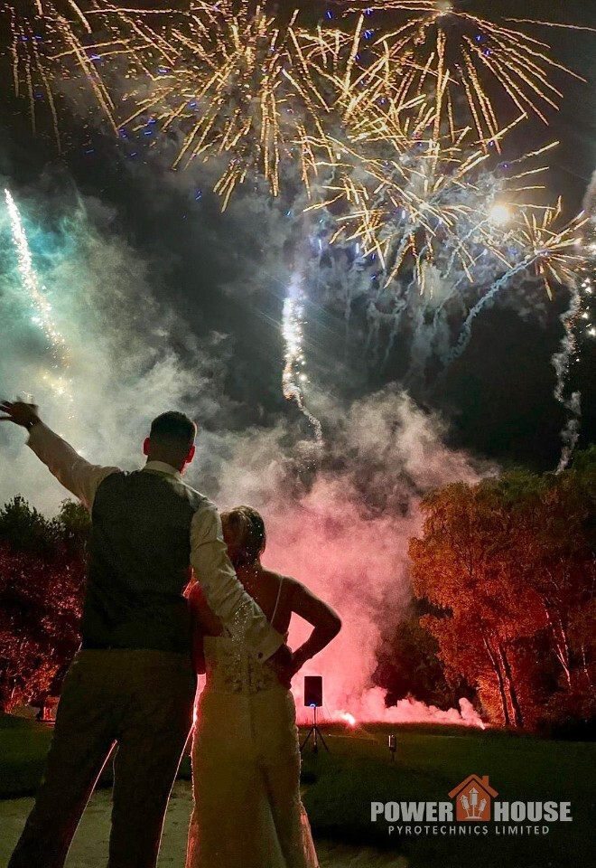Bride and groom watching a spectacular wedding fireworks display at Kingswood Golf Course, with golden fireworks lighting the night sky during an outdoor wedding celebration