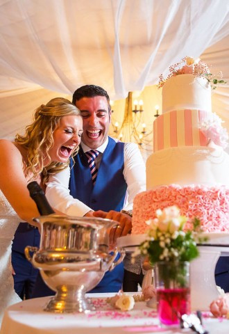 wedding cake cutting by bride and groom at their wedding reception 