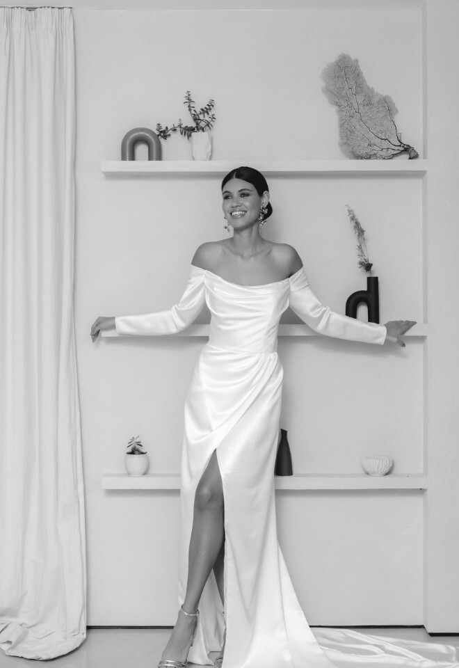 Satin wedding dress with leg split, off the shoulder neckline and detachable sleeves. Available at Your Story Bridal, Marlow