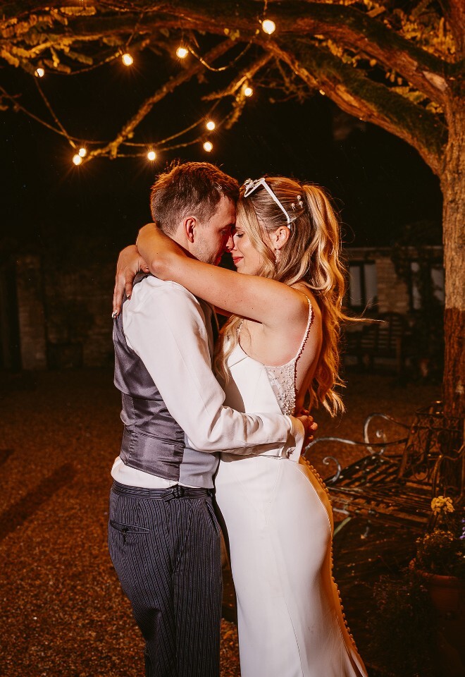 Merriscourt wedding photography of a couple embracing under tree lit up by fairy lights