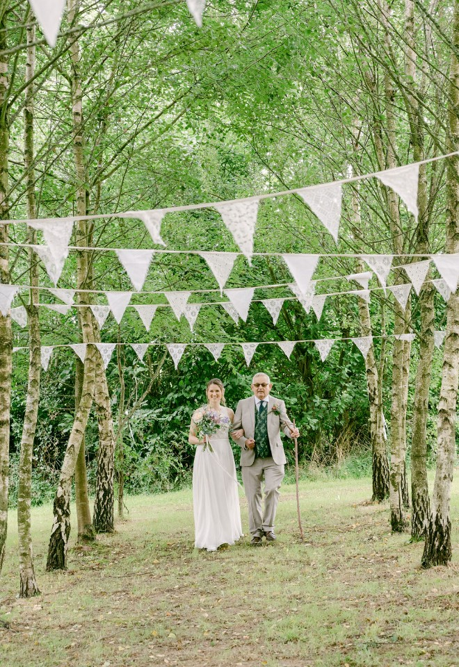 Walking down the aisle at Higher Holcombe outdoor wedding ceremony