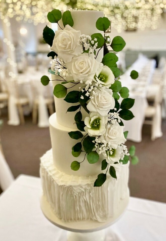 White wedding cake with foliage for a wedding at the Kings Chapel by Cakes of Curiosity.