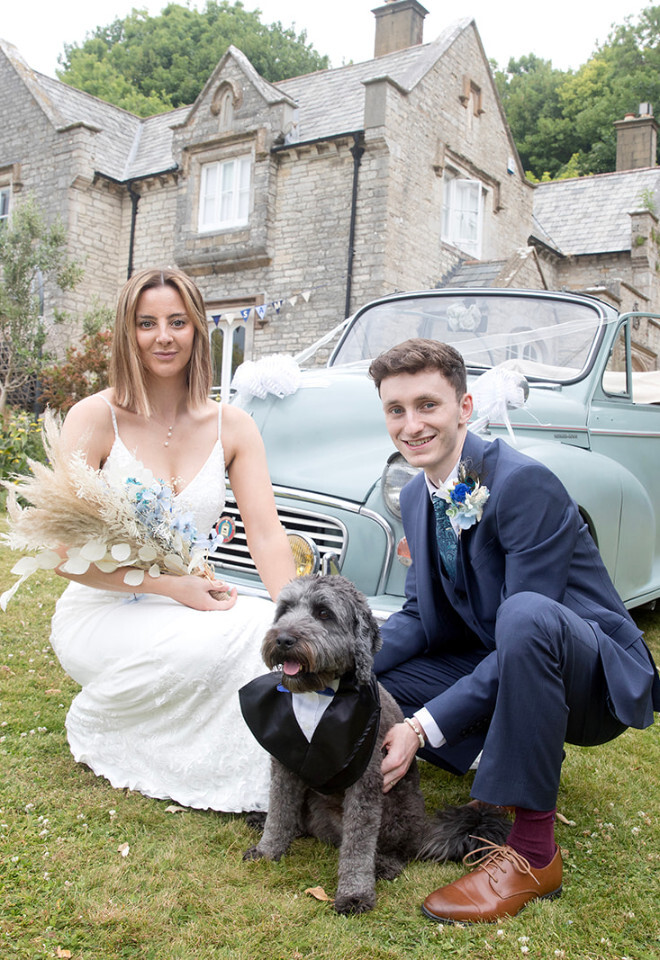 “Bride and groom with their dog in front of a vintage car at an outdoor wedding at Upwey House in Dorset by Katy Brothers Wedding Photography”