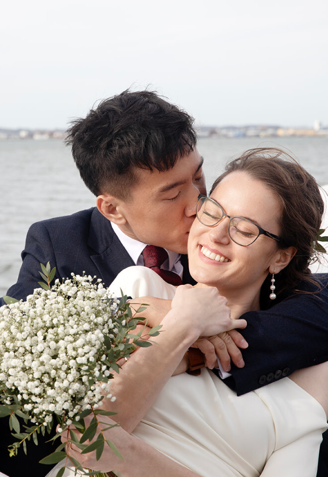 “Couple embracing on a boat during their Sandbanks wedding at the marina in Dorset, photographed by Katy Brothers Wedding Photography”