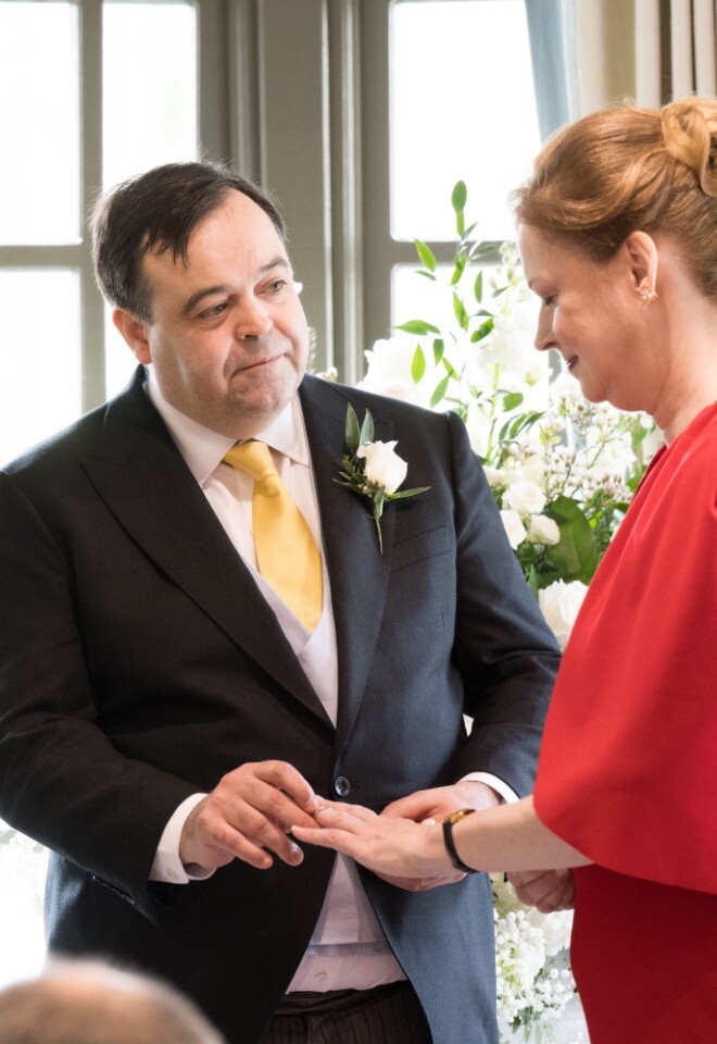 Groom placing ring on brides finger