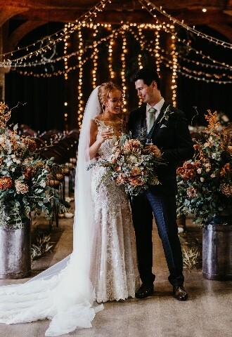 Bride and Groom Indoor Ceremony at Barn Venue with Autumn Flowers
