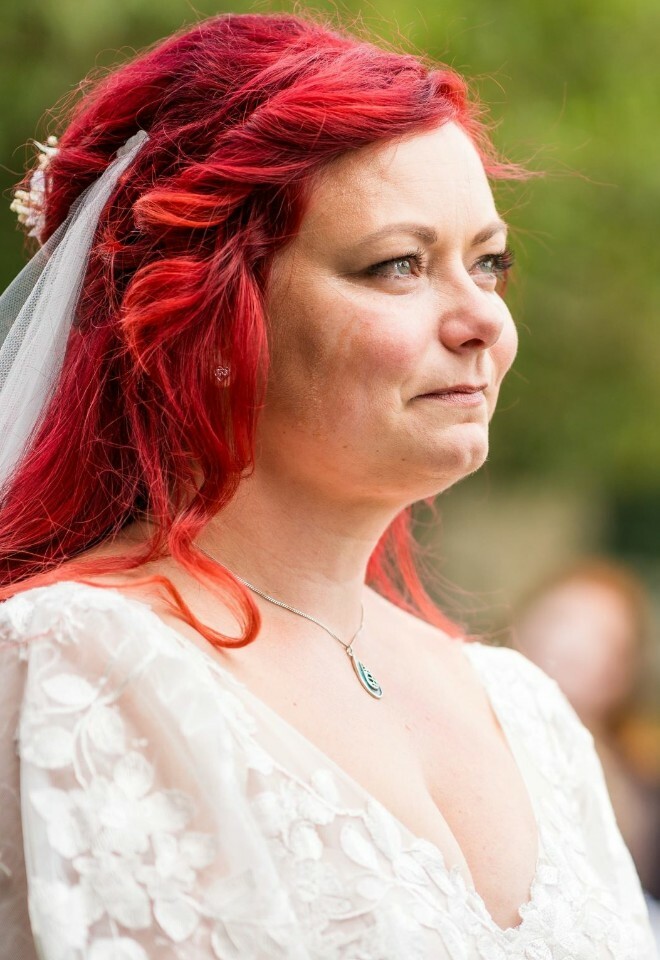 bride has tears in eyes as partner reads his vows