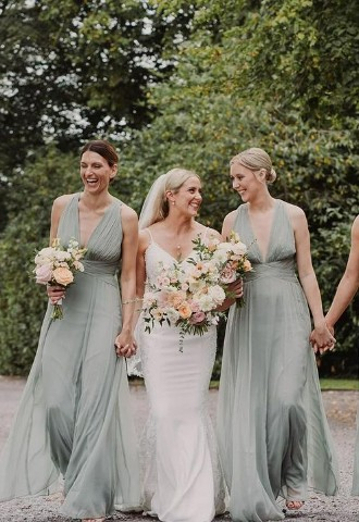 bridesmaids and brides holding hands and laughing at Stockton House