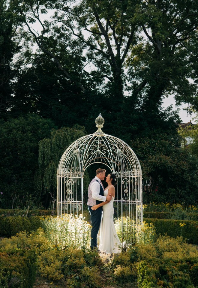 Couple photographed in front of birdcage structure