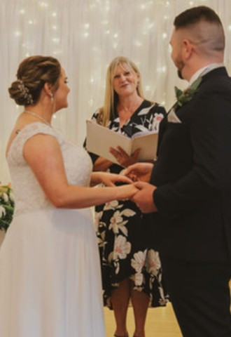 Celebrant with bride and groom in front of sparkly curtain at The Green