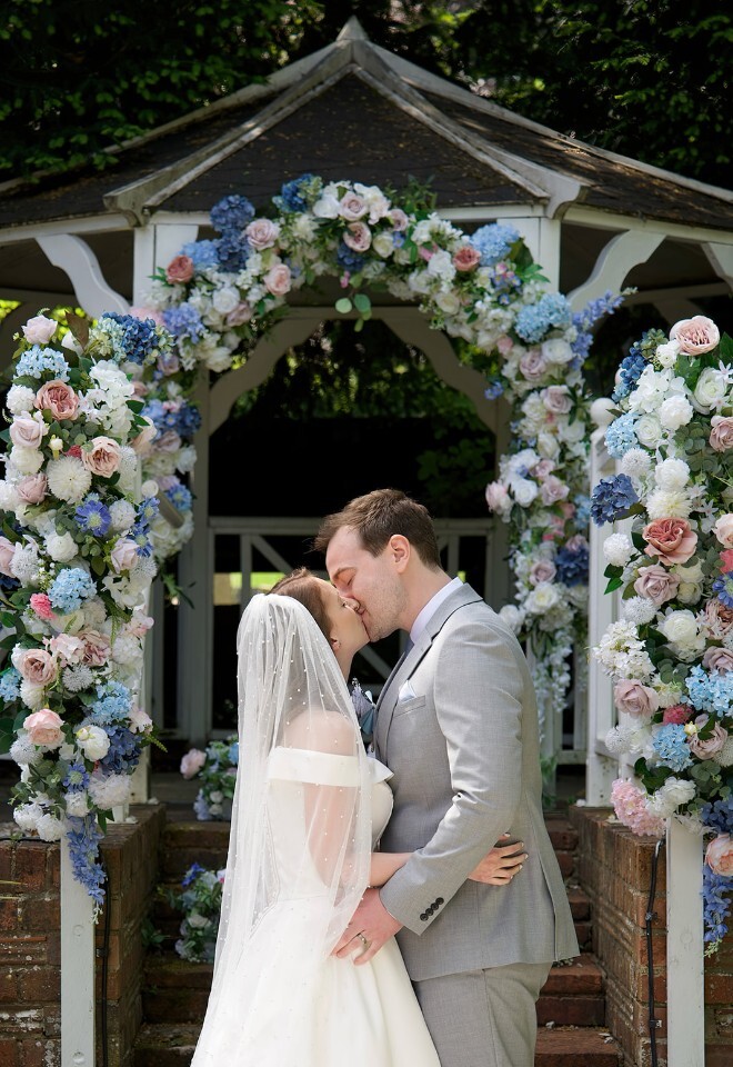 Beautiful pastel faux ceremony flowers on arch pavilion 