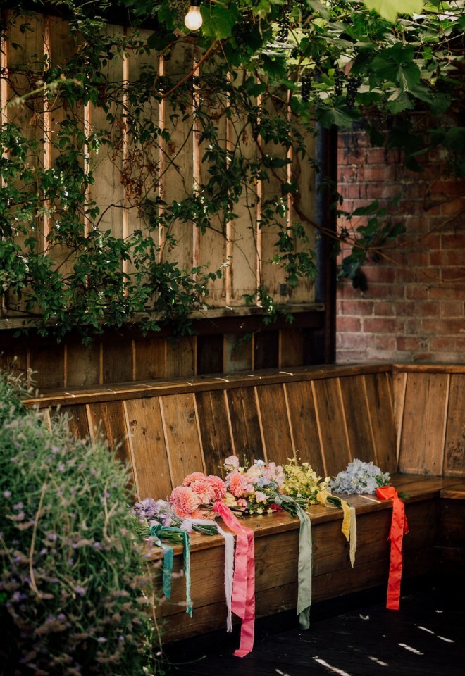 Outdoor seating area with multi coloured flower bouquets