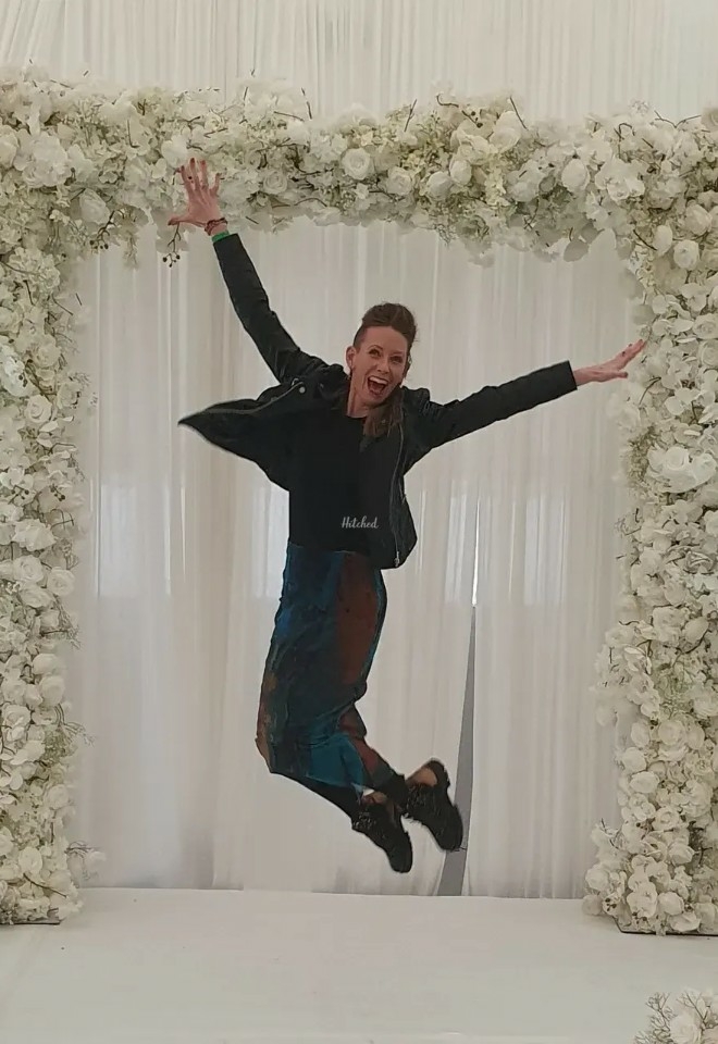 Celebrancy by Gabrielle jumping underneath a flower arch