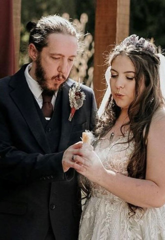 Celebrant with couple blowing out their marriage candle