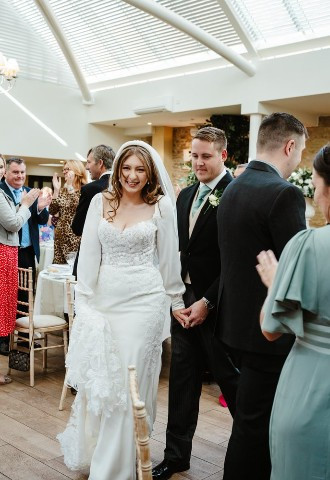 Bride and groom entering their wedding reception at voco Oxford Thames