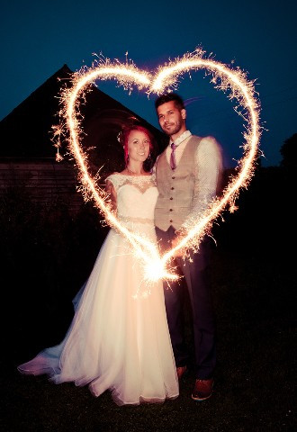 Oxfordshire Barn Wedding with bride and groom making a heart shape with sparklers
